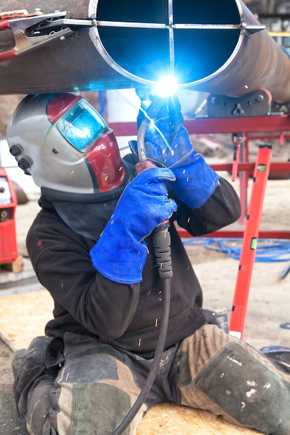 Ouvrier soudeur dans une usine. Soudage sur une installation industrielle.