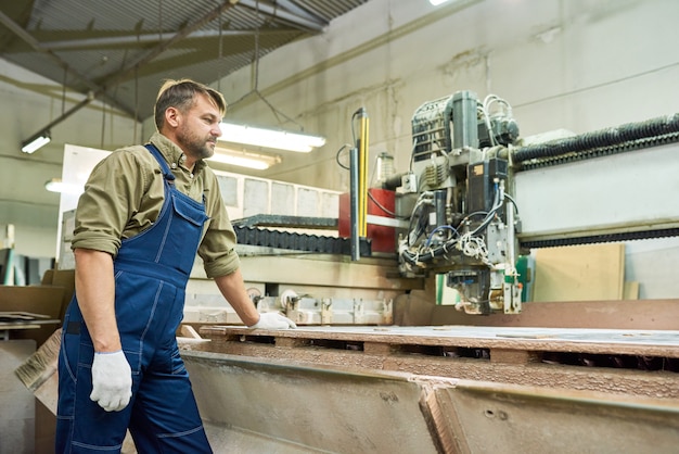 Ouvrier d'usine à l'aide de la machine de découpe