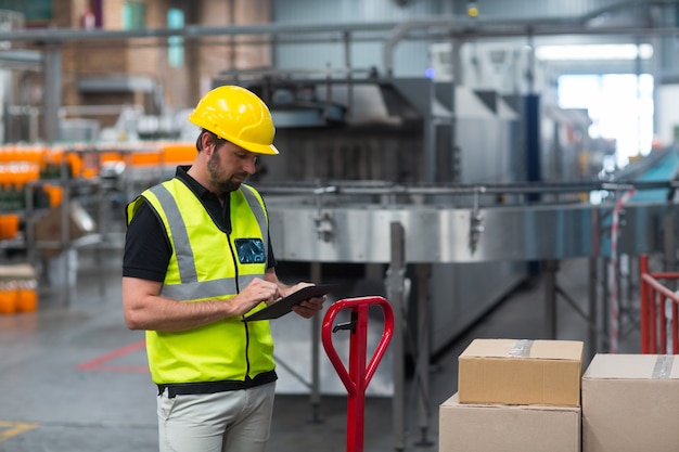 Ouvrier d'usine à l'aide d'une tablette numérique