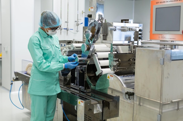 Ouvrier d'usine caucasien en costume de laboratoire bleu vérifier les lectures de la machine