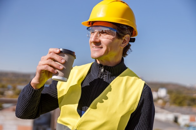 Ouvrier d'usine joyeux homme buvant du café à l'extérieur