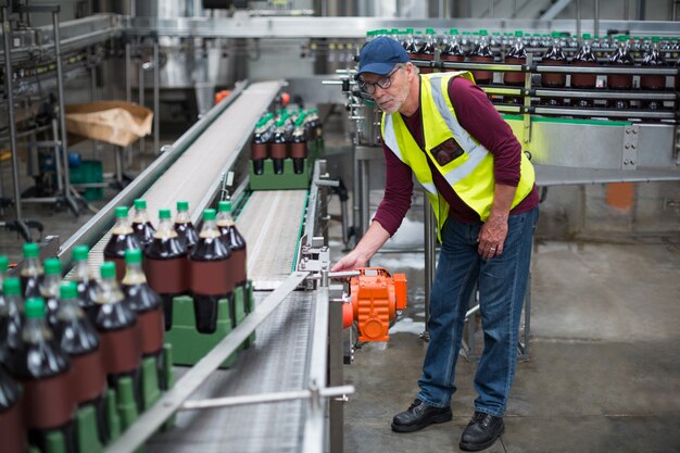 Ouvrier d'usine mâle inspectant la ligne de production