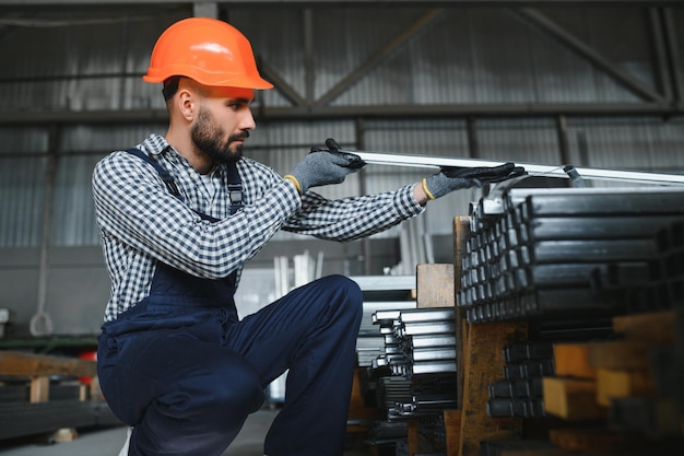 L'ouvrier d'usine mesure le profil en métal