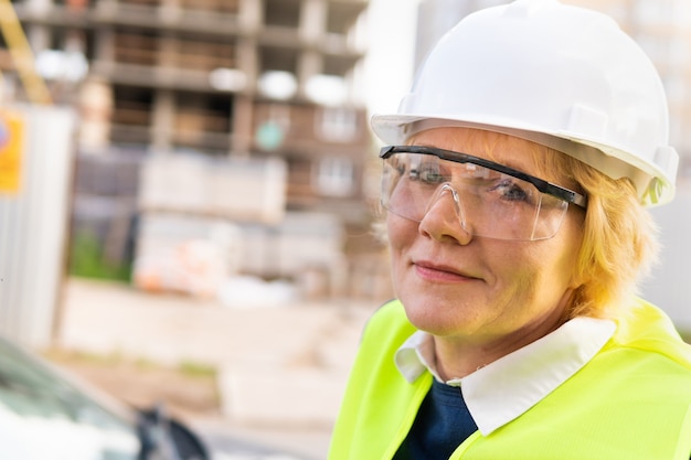 Photo une ouvrière sur un chantier de construction travaille et contrôle le processus.