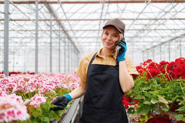 Ouvrière de serre de fleur femelle parlant au téléphone