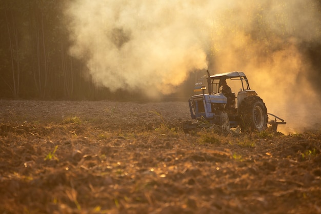 Photo les ouvriers agricoles asiatiques utilisent des tracteurs pour préparer le sol en vue de la plantation.
