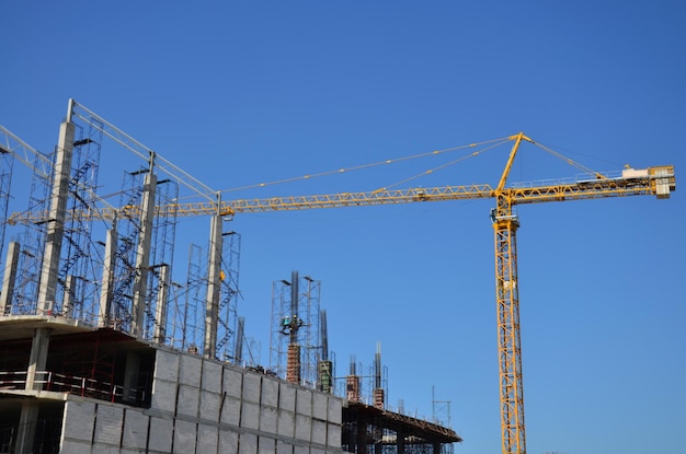 Des ouvriers asiatiques et des ouvriers thaïlandais utilisent des machines et des machines lourdes pour construire une nouvelle tour de structure sur un échafaudage sur un chantier de construction dans la capitale de Bangkok en Thaïlande