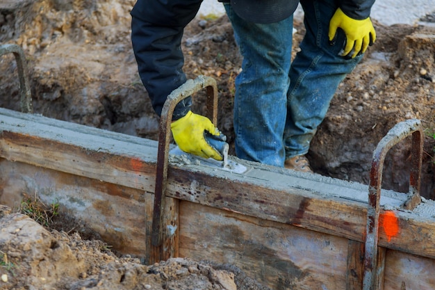 Ouvriers du bâtiment nivelant la chaussée en béton.