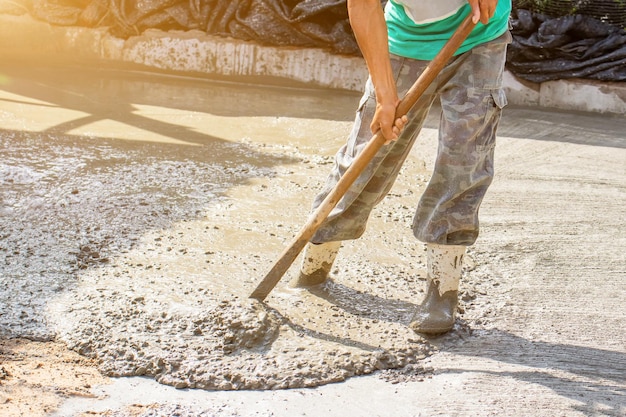 Les ouvriers versent du béton sur le site de constructionDes barres d'acier utilisées pour la construction de sols Des ouvriers versent pour la construction d'un immeuble résidentiel