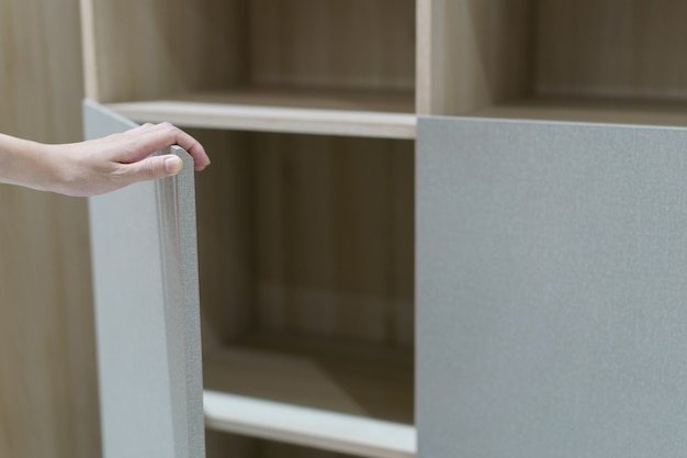 ouvrir à la main les portes de l'armoire, ouvrir l'armoire marron et blanche