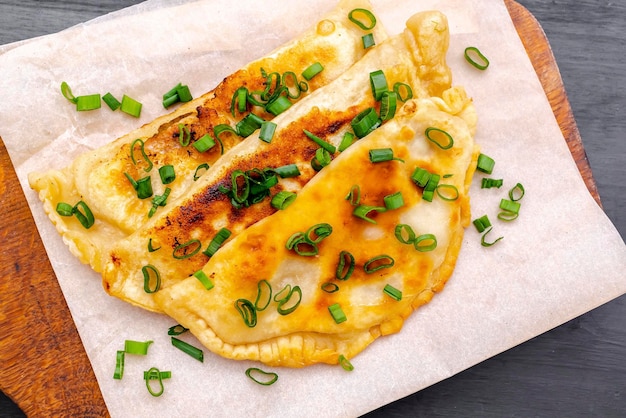 OuzbékistanCuisine tatarecheburek avec boeufviande de porcoignonsverts sur planche de boisPâtisseries de Cornouailles maison fraîchement cuitestarte aux ragoûts frits enveloppée dans une pâte briséePlat mongol turc traditionnel