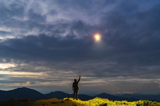 L'OVNI brille sur un homme debout sur la montagne