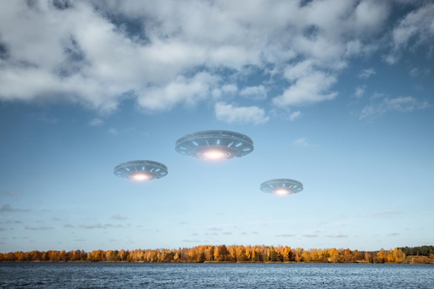 OVNI une soucoupe extraterrestre planant au-dessus du lac dans les nuages planant immobile dans le ciel Objet volant non identifié invasion extraterrestre vie extraterrestre voyage dans l'espace vaisseau spatial technique mixte