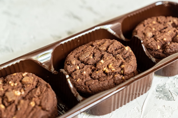 Pack de cookies au chocolat américain avec des noix sur fond en bois blanc. Pâtisserie fraîche.