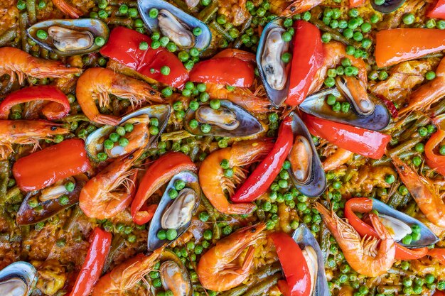 Paella espagnole aux fruits de mer dans une poêle à frire avec moules crevettes et légumes