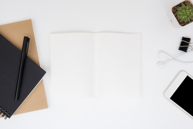 Page de cahier vierge sur la table de bureau blanc. Vue de dessus, plat poser.