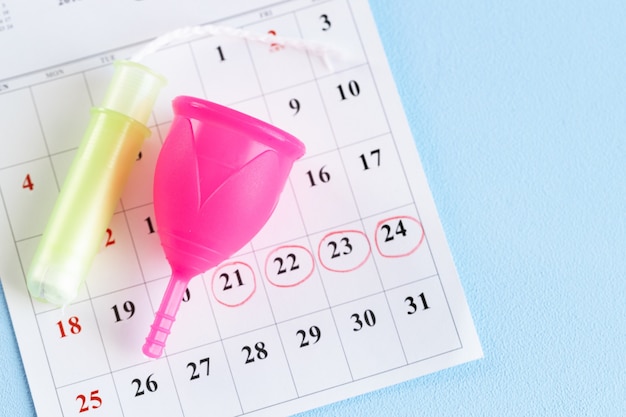 Page De Calendrier Et Coupe Menstruelle Se Bouchent Sur La Table