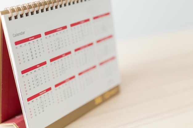 Page de calendrier gros plan sur une table en bois avec fond de mur blanc concept de réunion de rendez-vous de planification d'entreprise