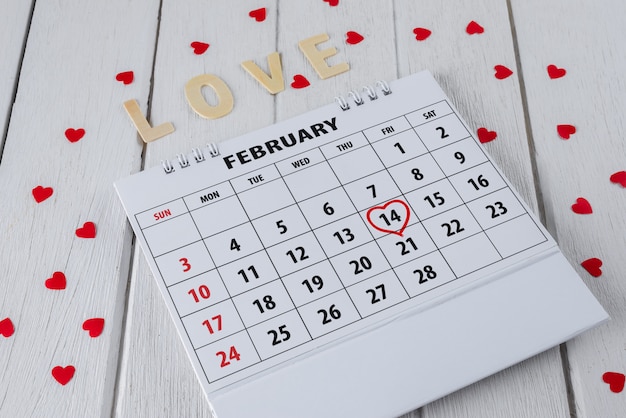 Page du calendrier avec une main rouge surlignée en coeur le 14 février de la Saint-Valentin