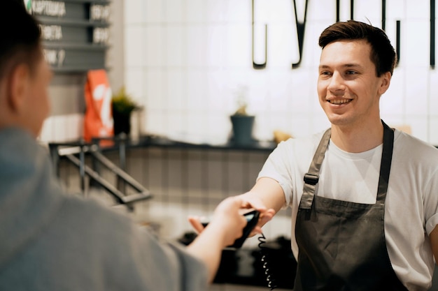 Paiement de l'encaissement de la facture par téléphone au restaurant Le serveur accepte le paiement NFC