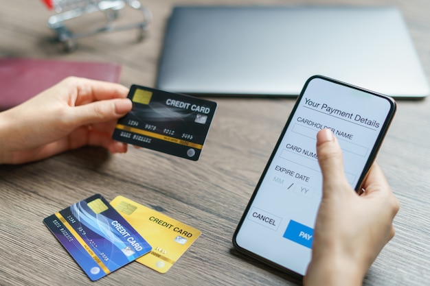 Paiements mobiles. mains à l'aide de smartphone et carte de crédit pour les achats en ligne. (Faux écran)