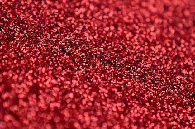 Paillettes décoratives rouge cramoisi. image avec des lumières brillantes de bokeh de petits éléments