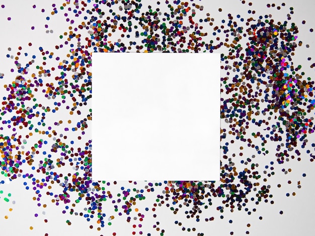 Paillettes avec du papier blanc sur la vue de dessus plat de Noël blanc