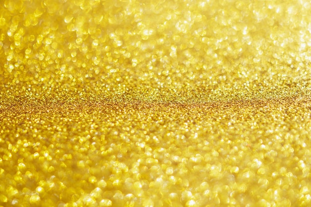 Des paillettes d'or abstraites scintillent avec un fond clair bokeh