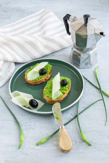 Pain à l'ail Tranches de baguette avec beurre à l'ail olives fromage et flèches à l'ail dans une assiette verte