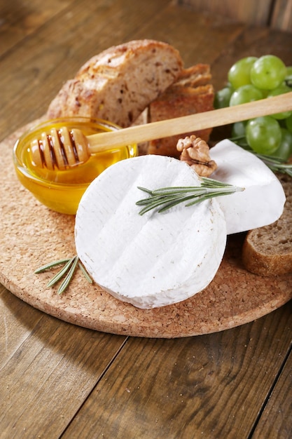 Pain au camembert miel et raisins sur une planche à découper sur fond de bois