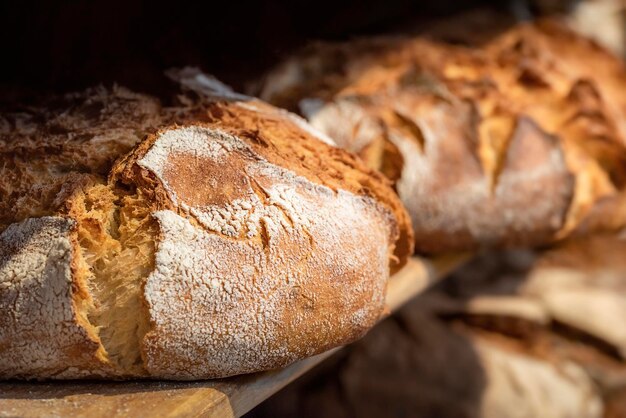 Pain au levain sur étagères en bois Étagère de boulangerie avec pain à croûte dorée