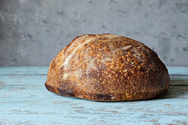 Pain au levain frais fait maison avec de la farine de grains entiers sur fond gris-bleu. Nourriture saine.