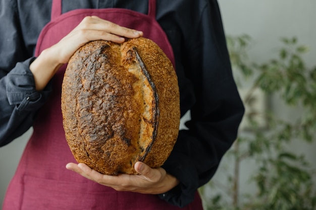 Pain au levain sans levure une belle boulangère européenne tient du pain dans ses mains