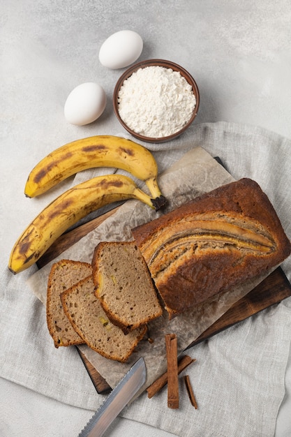 Pain aux bananes fraîches en tranches avec des ingrédients sur fond clair