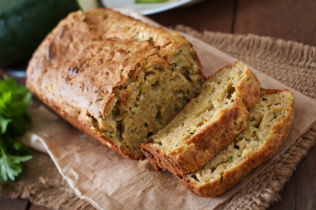 Pain aux courgettes avec du fromage sur une table en bois