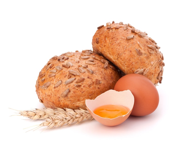 Pain aux graines et oeuf cassé isolé sur fond blanc