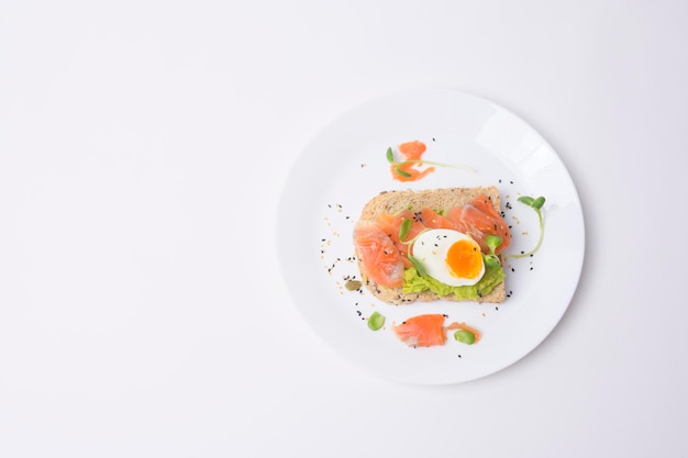 Pain avec avocat légumes fruits et oeuf sur fond blanc Concept de petit-déjeuner sain