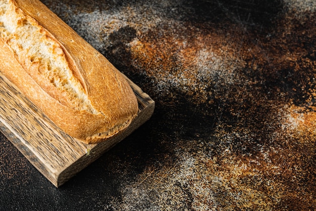 Pain baguette, sur vieux fond rustique foncé avec espace de copie pour le texte