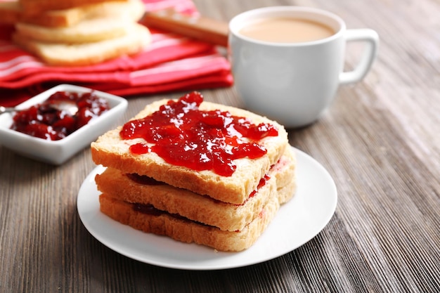 Pain avec beurre et confiture maison sur table en bois agrandi