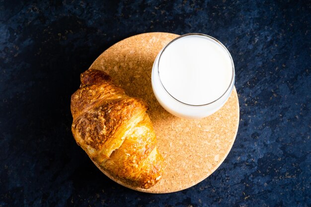 Pain blanc frais et lait en verre blanc sur fond de table en pierre noire vue de dessus et prise de vue en studio