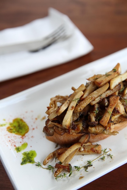 Pain blanc grillé croustillant aux champignons sur table de fond en bois