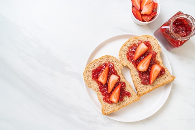 pain de blé entier avec confiture de fraises et fraises fraîches