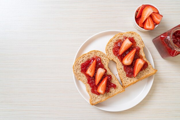 pain de blé entier avec confiture de fraises et fraises fraîches