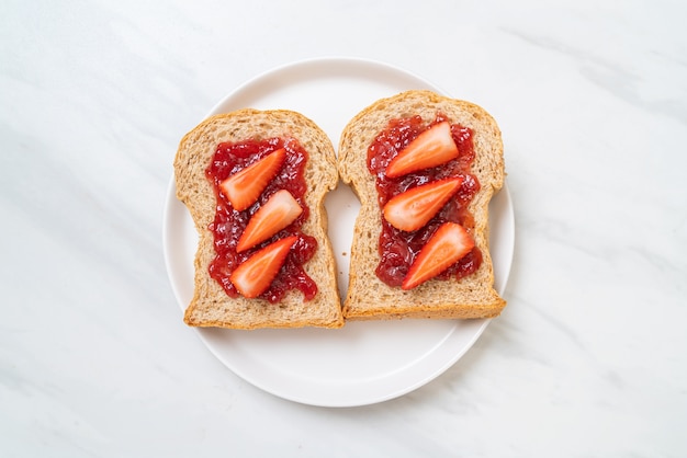 Pain de blé entier fait maison avec confiture de fraise et fraise fraîche