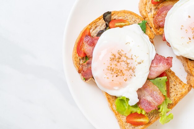 Pain de blé entier grillé avec légumes, bacon et œuf ou œuf bénédictine pour le petit-déjeuner