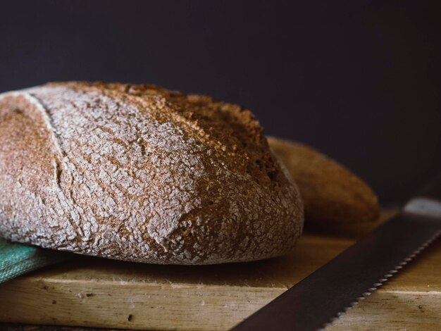 Pain de blé entier tranché sur une planche à découper en bois