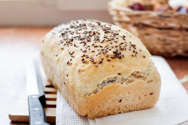 Pain de blé fait maison avec des graines de lin sur une table de cuisine