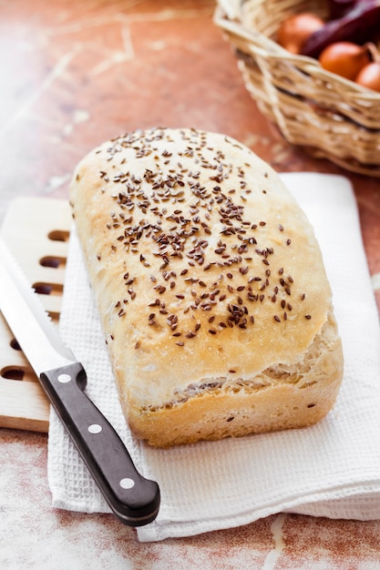 Pain de blé fait maison avec des graines de lin sur une table de cuisine