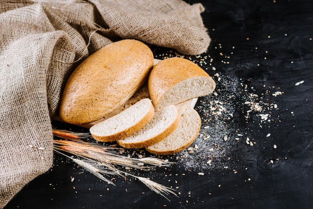 Pain et blé sucrés et savoureux sur fond de bois noir