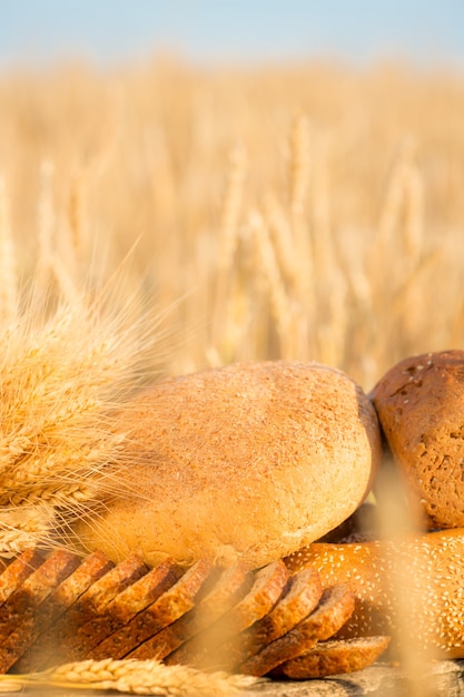 Pain et blé sur la table en bois dans le domaine d'automne